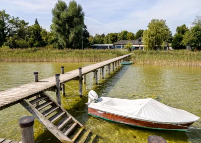 Steg am Seehaus Riederau bei Hochzeitsfeier, Boot und Steg im klaren Wassersemblage natürlicher Kulisse.