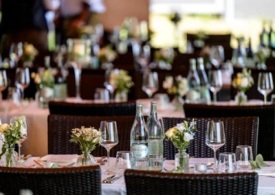 Hochzeitsfeier im Seehaus Riederau, eleganter Tisch mit Blumenarrangement und Gläsern.