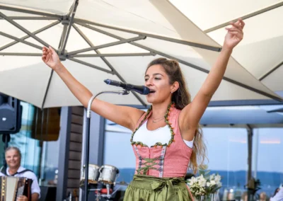 Sängerin bei Hochzeit im Seehaus Riederau am Ammersee, Hochzeitsparty-Stimmung unter Sonnenschirm.