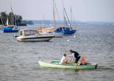 Hochzeitsreportage auf See: Familie im Boot, Brautpaar-Shooting, romantische Kulisse mit Segelbooten.
