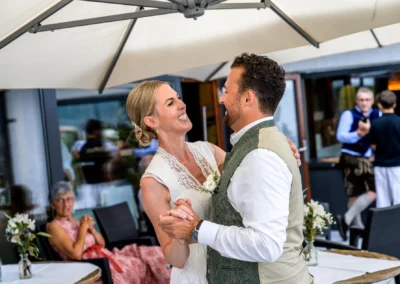 Tanzendes Brautpaar bei einer Hochzeitsfeier im Freien, fröhliche Stimmung, Hochzeitsfotografen-Reportage.