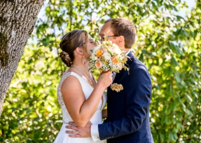 Brautpaar küsst sich im Grünen während eines Fotoshootings in Bad Wiessee am Tegernsee.
