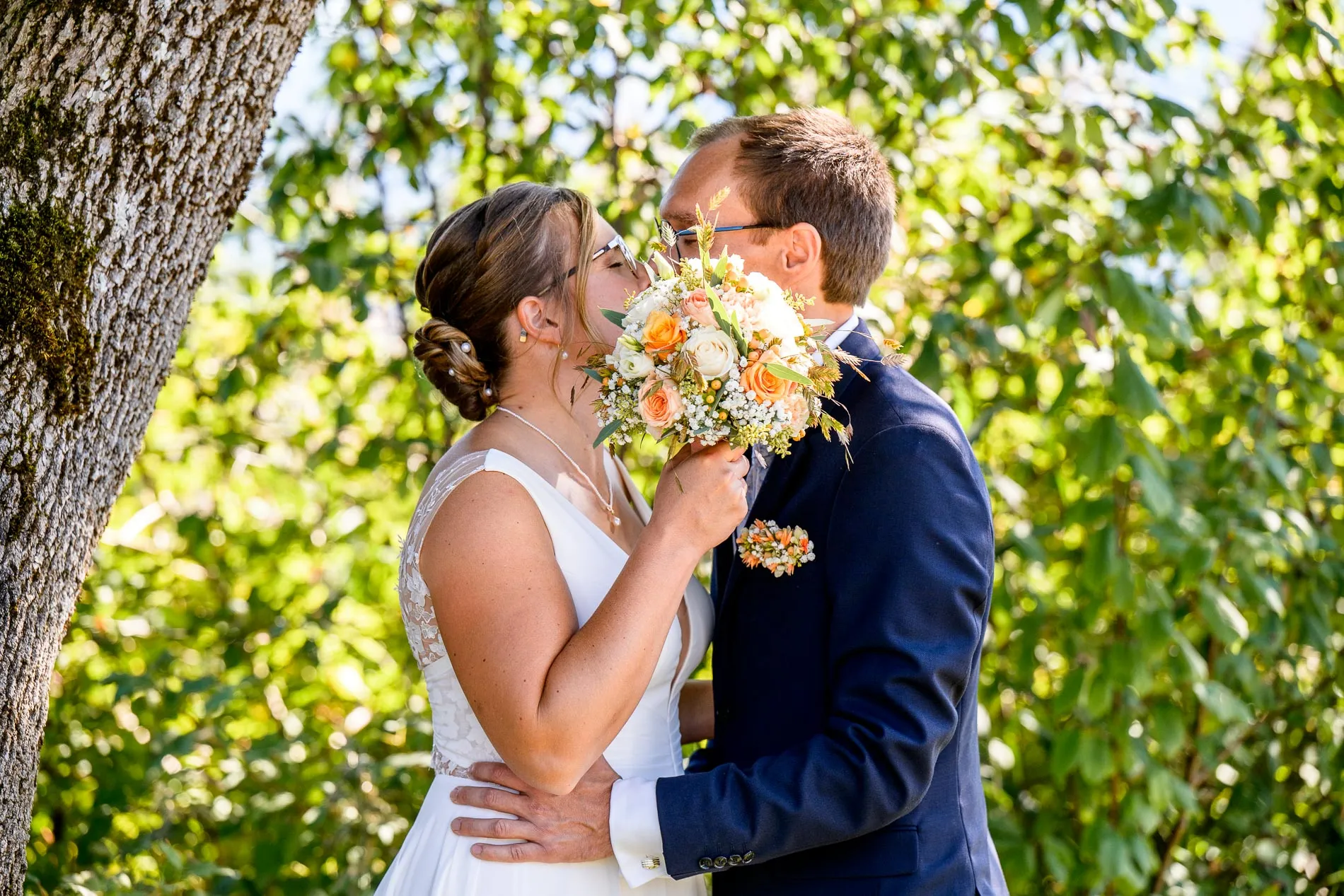 Brautpaar küsst sich im Grünen während eines Fotoshootings in Bad Wiessee am Tegernsee.
