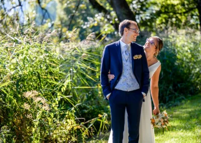 Brautpaar-Shooting in Bad Wiessee am Tegernsee, romantisch im Freien bei sonnigem Wetter, Braut mit Blumenstrauß.