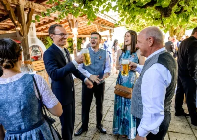 Gäste stoßen bei einer Hochzeitsfeier im Terrassenhof Bad Wiessee mit Bier an.