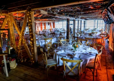 Romantische Hochzeitsfeier im Bootshaus des Terrassenhofs Bad Wiessee bei Abendstimmung, elegant dekoriert.