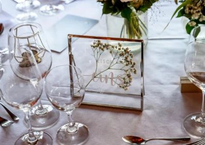 Hochzeitsfeier im Bootshaus Terrassenhof Bad Wiessee, elegant gedeckter Tisch mit Blumendekor und Glas.