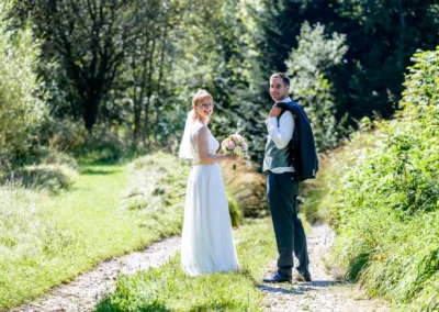 Brautpaar-Shooting auf einem Waldweg in Pfaffing bei Ebersberg, festgehalten von Hochzeitsfotografen.