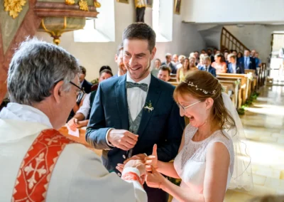 Brautpaar tauscht Ringe während kirchlicher Trauung in St. Margaretha, Pfaffing bei Ebersberg. Emotionale Hochzeitsmomente.