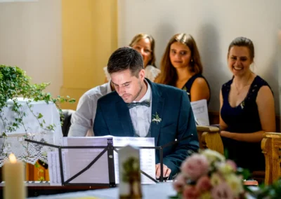 Der Bräutigam spielt Orgel bei kirchlicher Trauung in St. Margaretha, Pfaffing. Hochzeitsreportage-Fotografie.